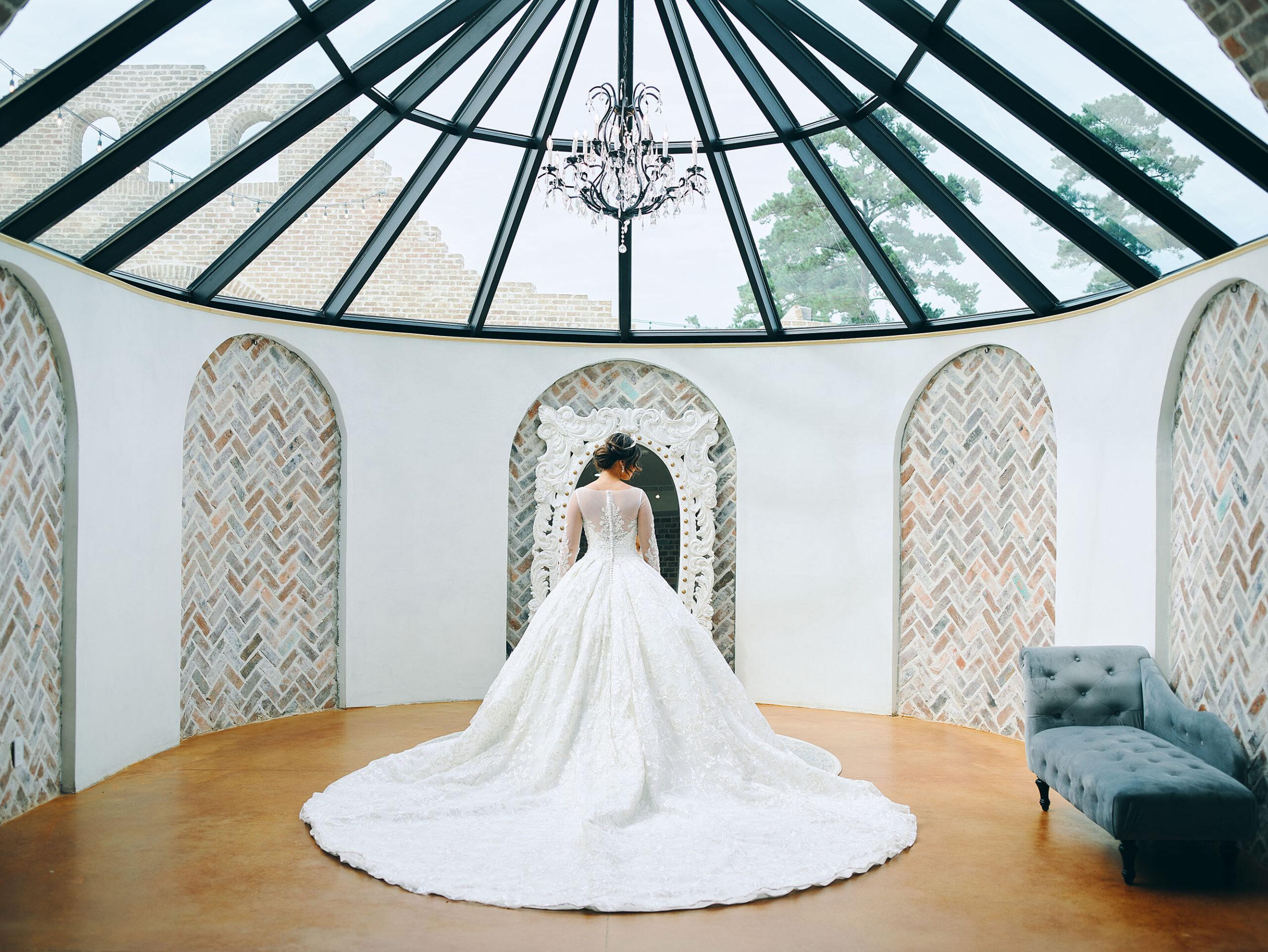 luxurious indoor wedding ceremony decor design, with a large red, yellow, and orange floral designs and a colorful bridal bouquet.