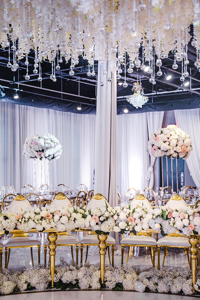 ceiling decor, cake drop, royal luxury, wedding reception decor, gold chairs, mirror tables, chargers, tableware, circle arch