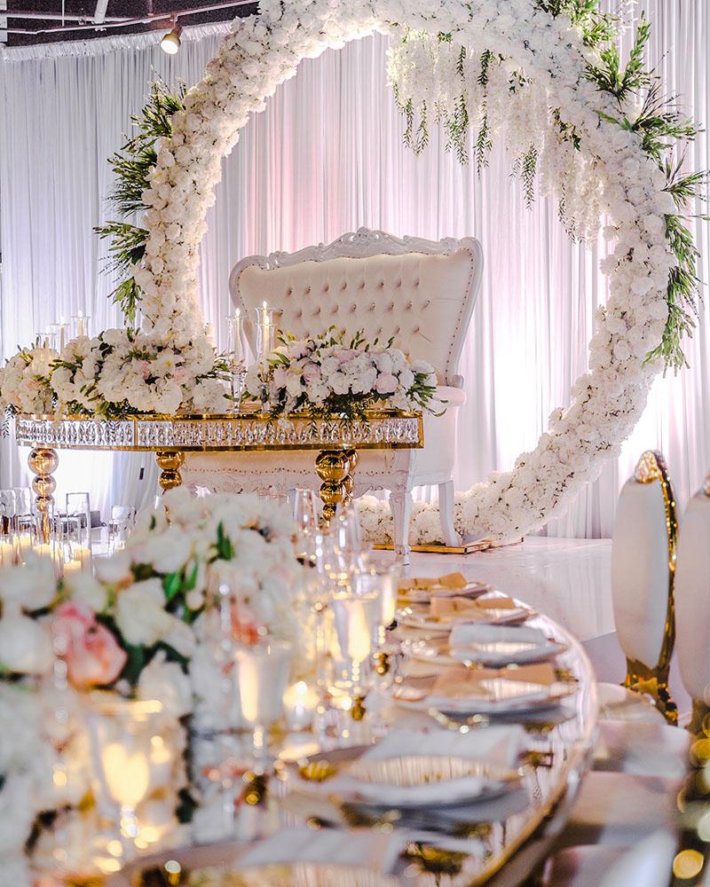 ceiling decor, cake drop, royal luxury, wedding reception decor, gold chairs, mirror tables, chargers, tableware, circle arch
