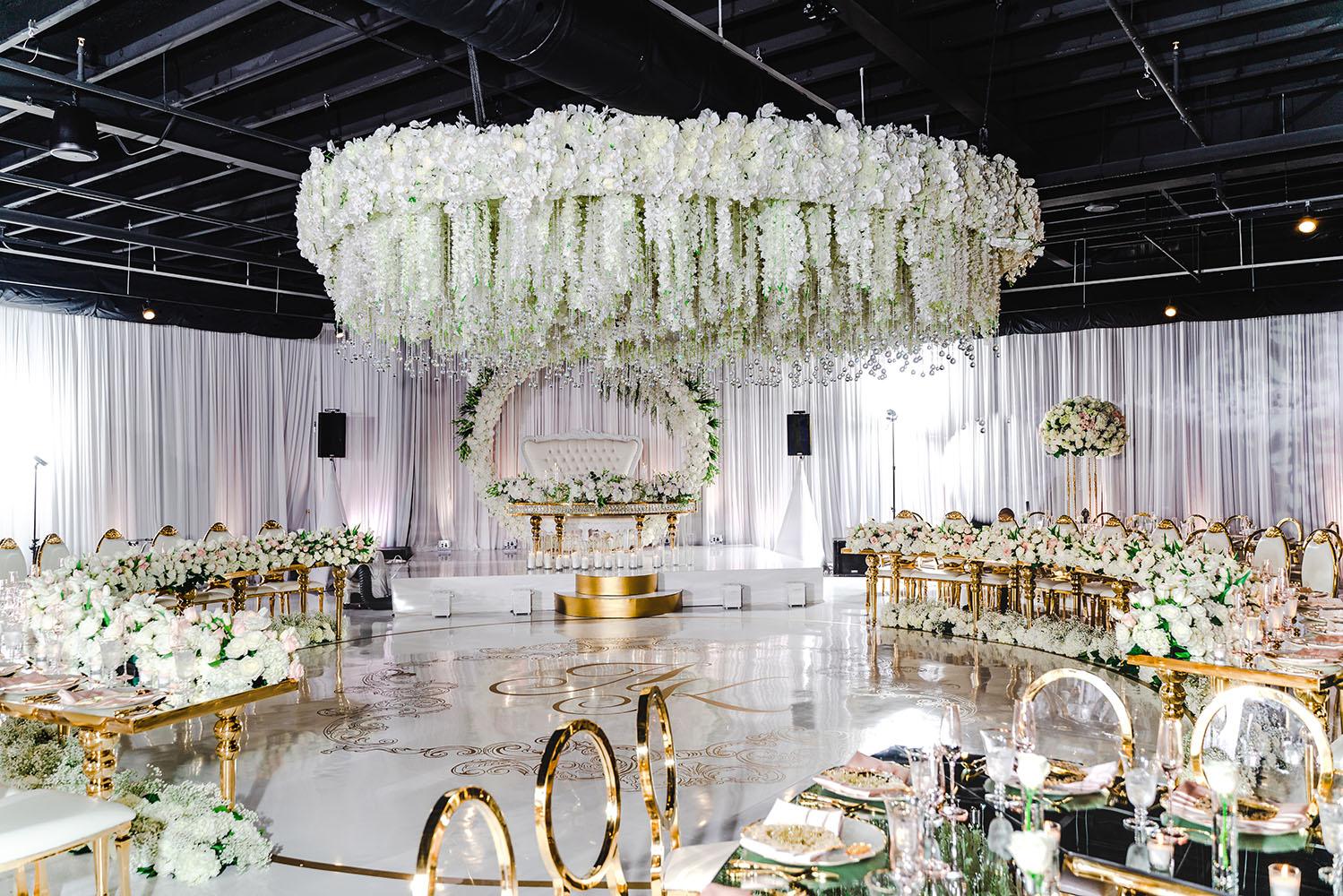 ceiling decor, cake drop, royal luxury, wedding reception decor, gold chairs, mirror tables, chargers, tableware, circle arch