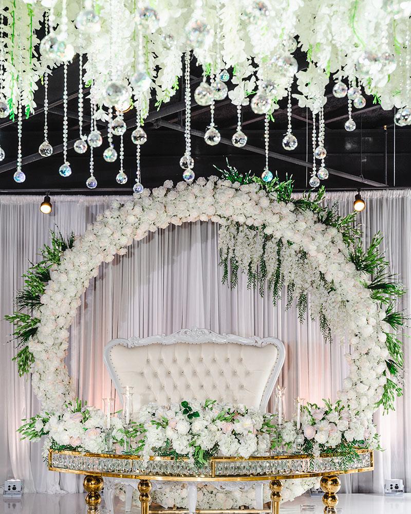ceiling decor, cake drop, royal luxury, wedding reception decor, gold chairs, mirror tables, chargers, tableware, circle arch