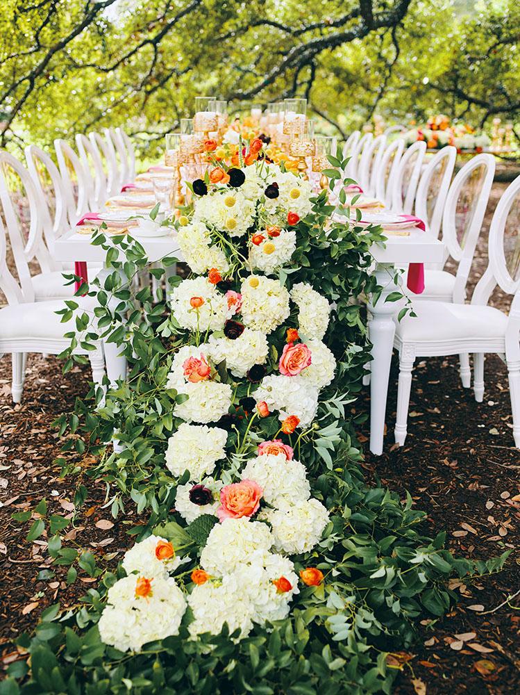 outdoor wedding reception - white chairs - pink napkins, charger plates, gold tableware, floral table runner, wedding cake, pink, yellow, orange, bouquet, houstonian, royal luxury events