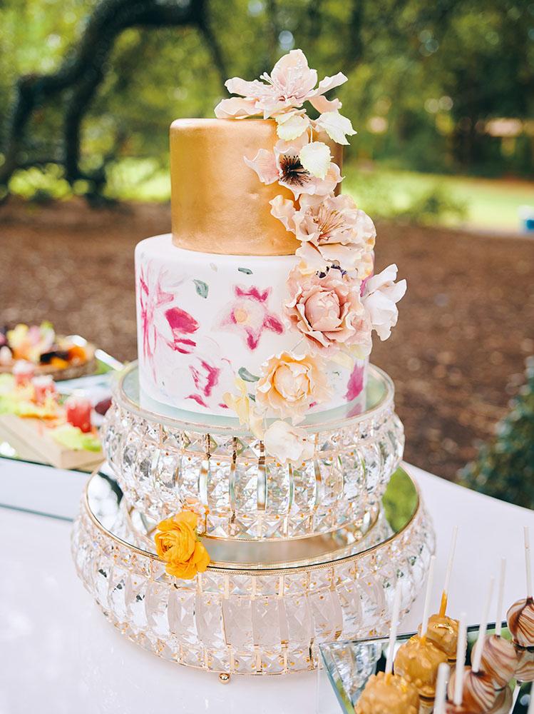 outdoor wedding reception - white chairs - pink napkins, charger plates, gold tableware, floral table runner, wedding cake, pink, yellow, orange, bouquet, houstonian, royal luxury events