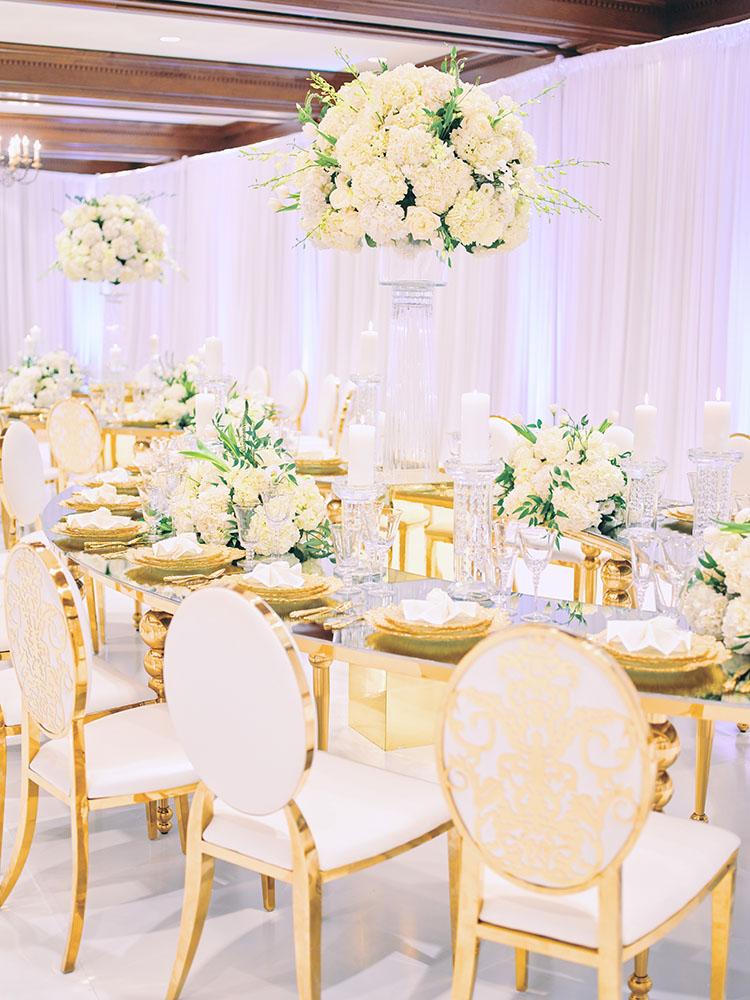 indoor wedding reception decor, white gold, wedding cake, gold chargers, mirror teardrop tables, centerpieces, florist, houstonian, luxury wedding in houston
