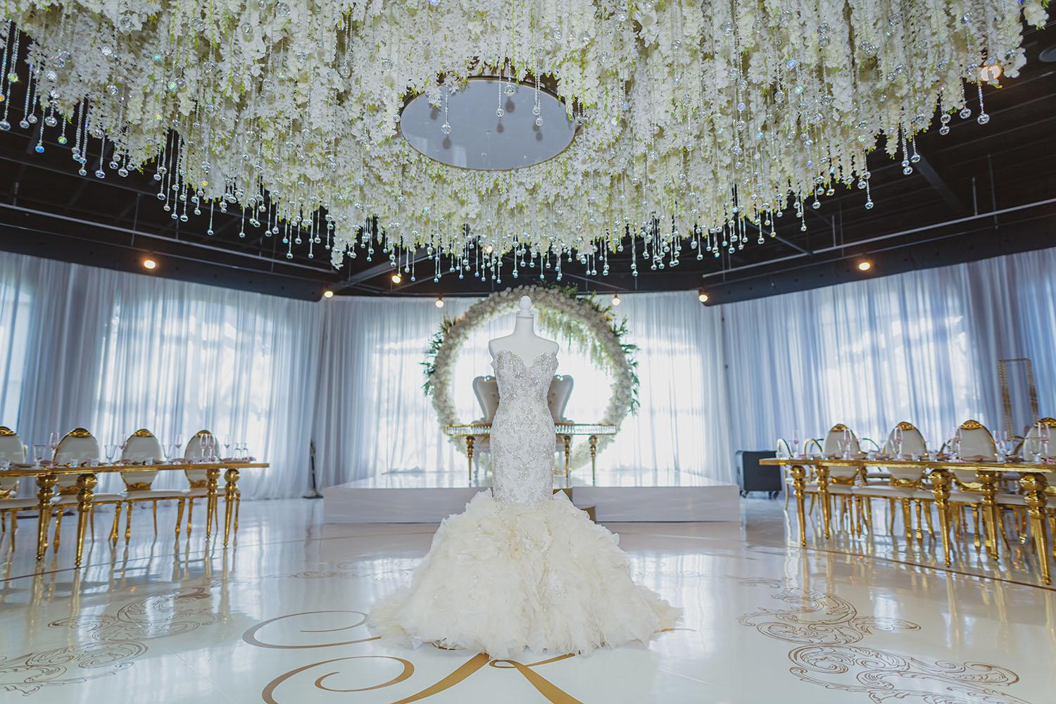 ceiling decor, cake drop, royal luxury, wedding reception decor, gold chairs, mirror tables, chargers, tableware, circle arch