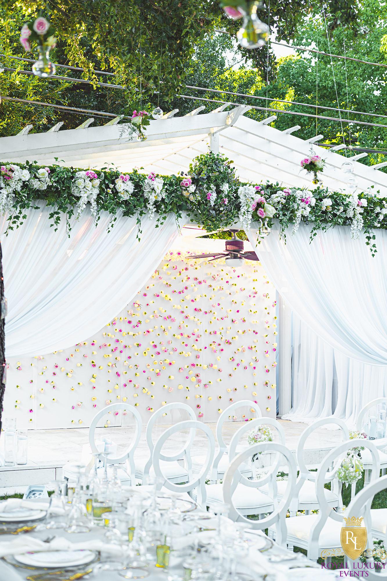 intimate backyard wedding decor featured pastel florals, white chairs, a greenery wall, and many other unique details - houston wedding decor