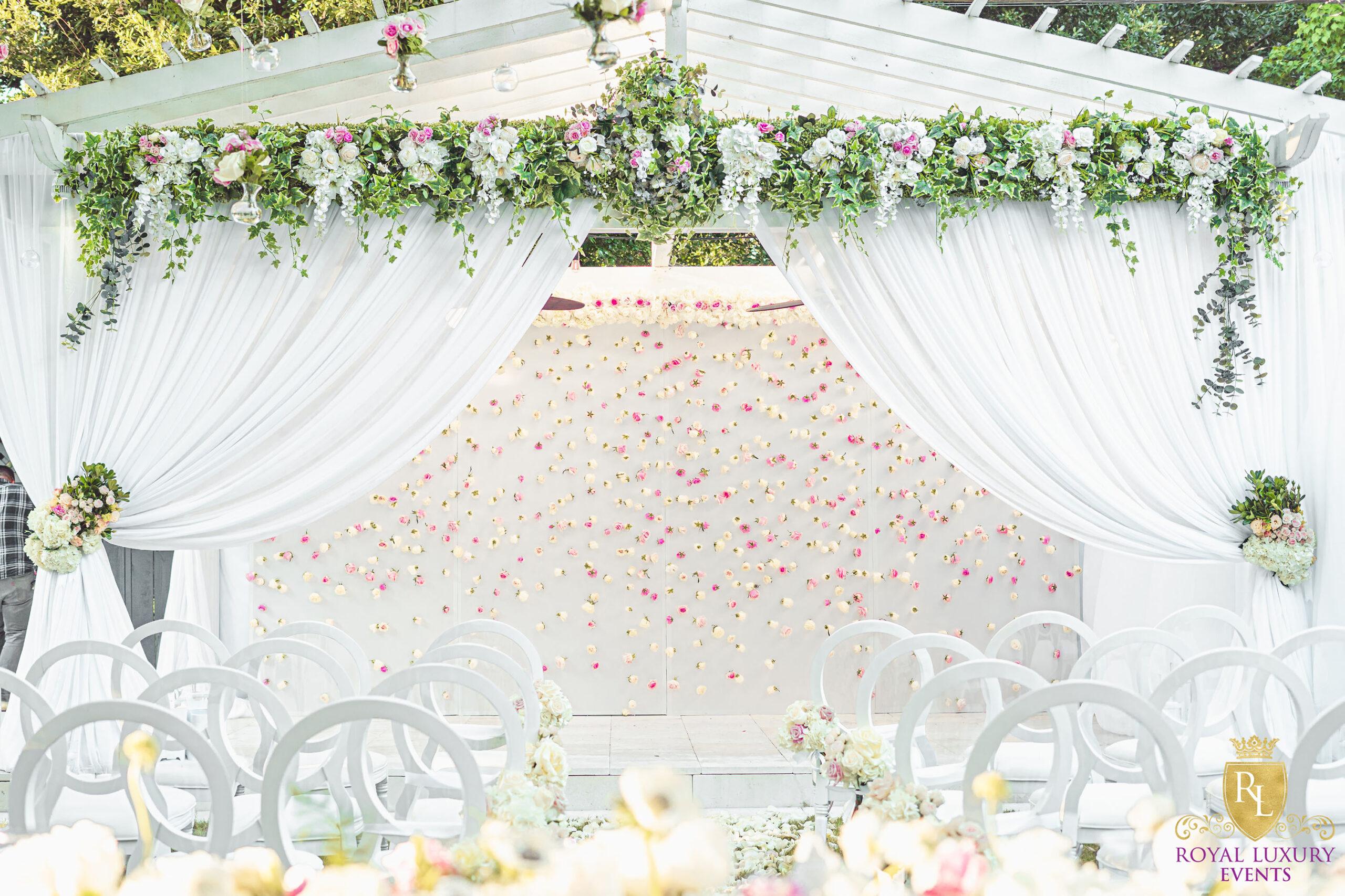 intimate backyard wedding decor featured pastel florals, white chairs, a greenery wall, and many other unique details - houston wedding decor