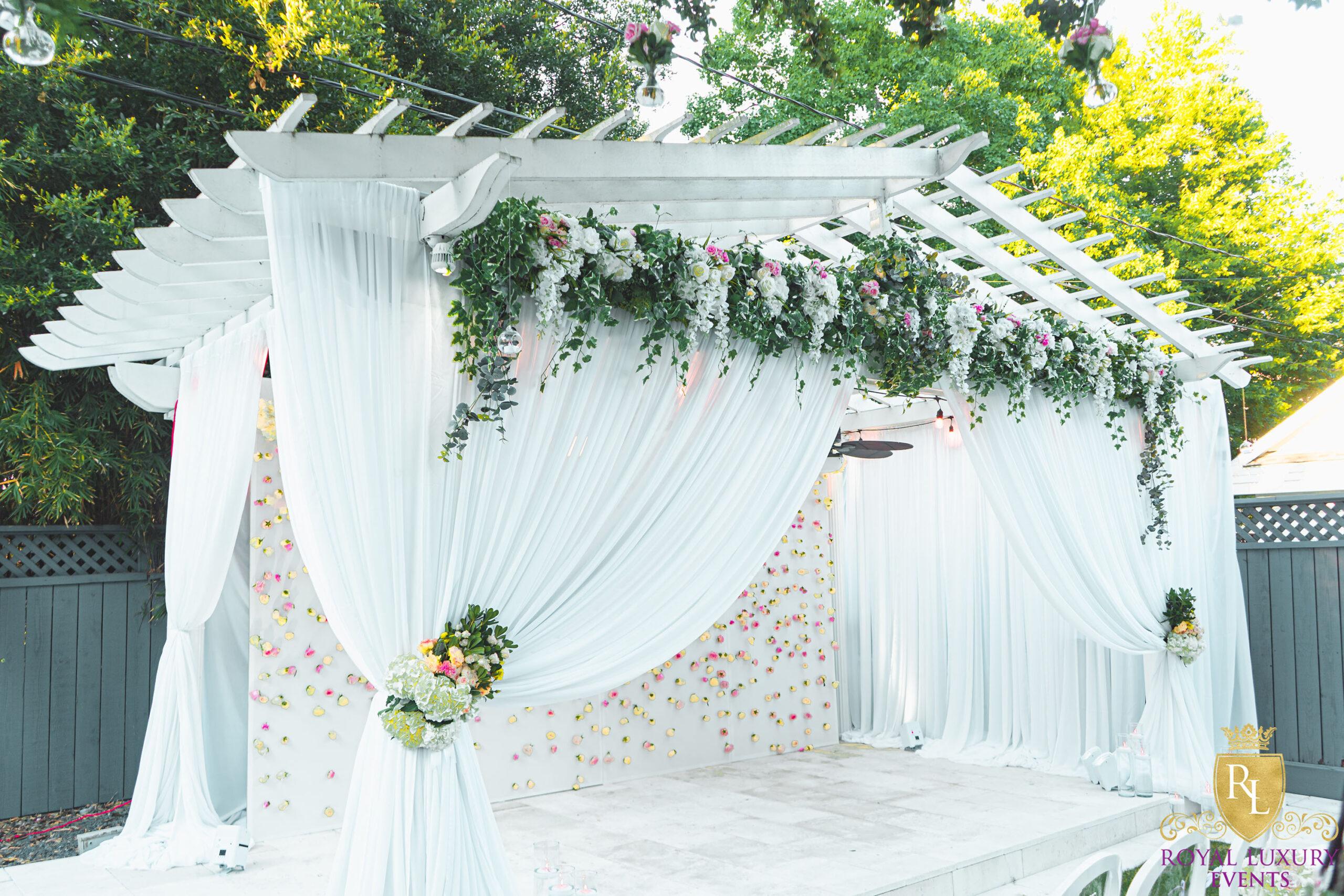 intimate backyard wedding decor featured pastel florals, white chairs, a greenery wall, and many other unique details - houston wedding decor
