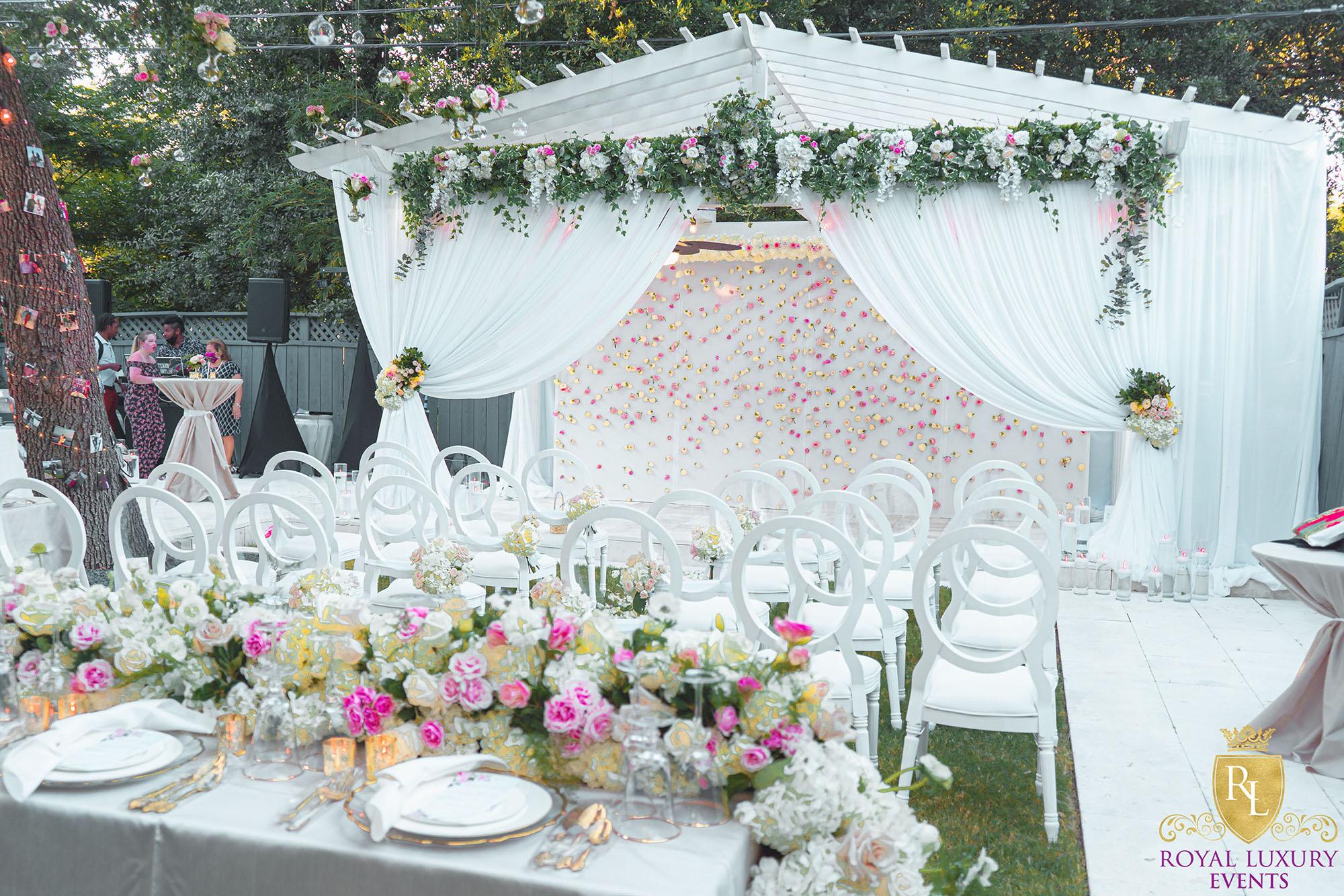 intimate backyard wedding decor featured pastel florals, white chairs, a greenery wall, and many other unique details - houston wedding decor