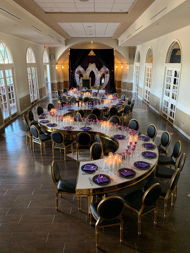 rehearsal dinner - black chairs - purple napkins - pink flowers - backdrop - bougainvilleas - serpentine tables