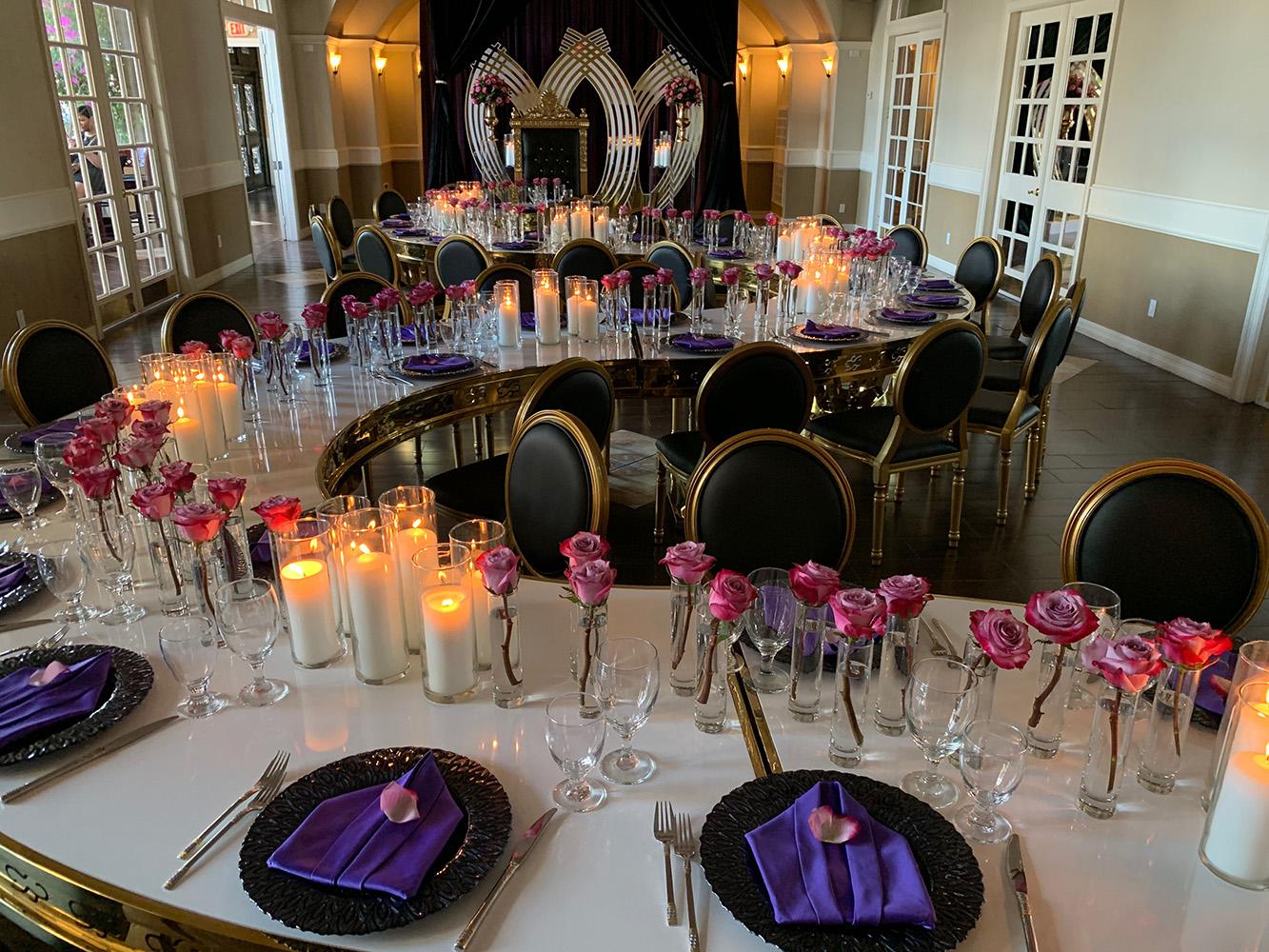 rehearsal dinner - black chairs - purple napkins - pink flowers - backdrop - bougainvilleas - serpentine tables - black charger plates