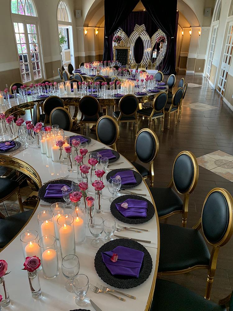 rehearsal dinner - black chairs - purple napkins - pink flowers - backdrop - bougainvilleas - serpentine tables - black charger plates