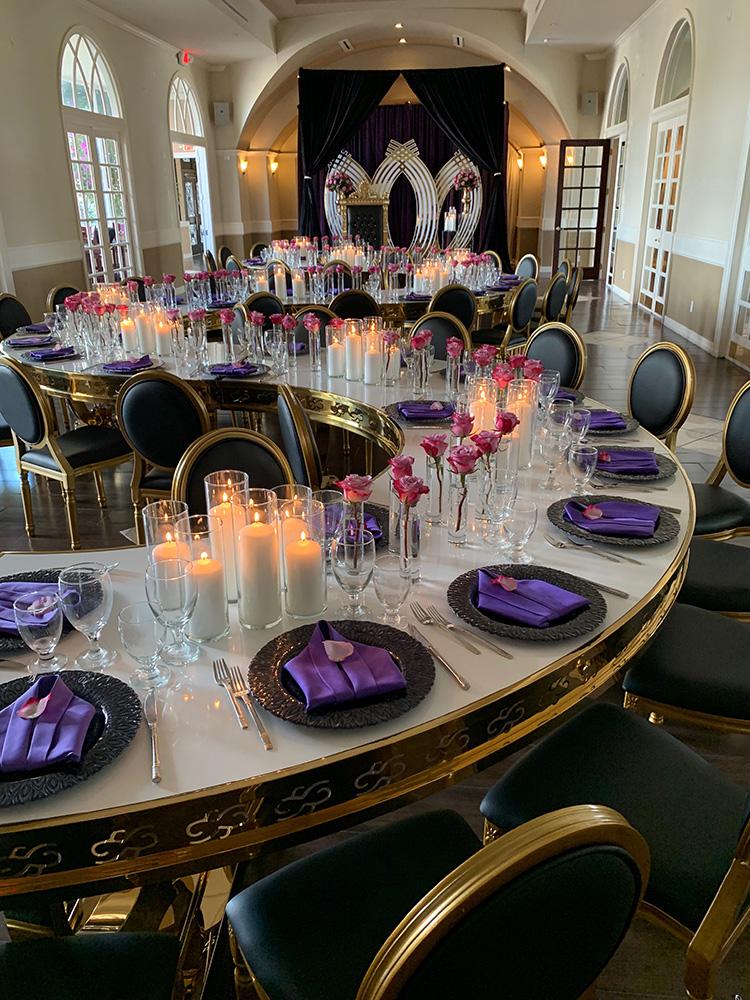 rehearsal dinner - black chairs - purple napkins - pink flowers - backdrop - bougainvilleas - serpentine tables - black charger plates