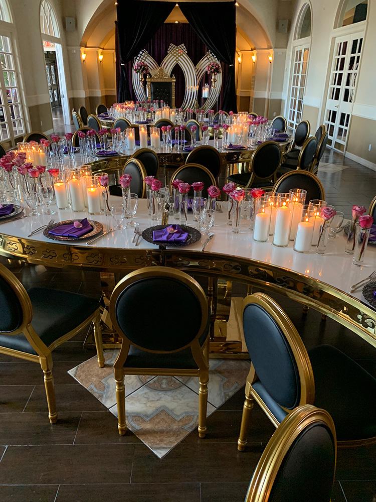 rehearsal dinner - black chairs - purple napkins - pink flowers - backdrop - bougainvilleas - serpentine tables - black charger plates