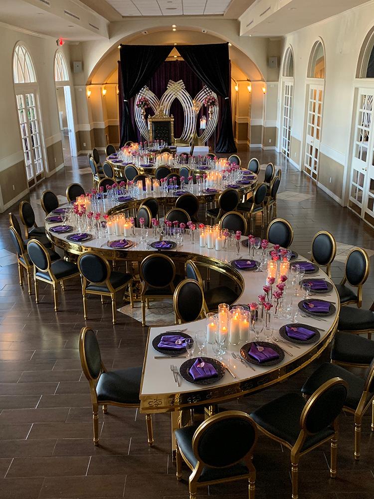 rehearsal dinner - black chairs - purple napkins - pink flowers - backdrop - bougainvilleas - serpentine tables - black charger plates