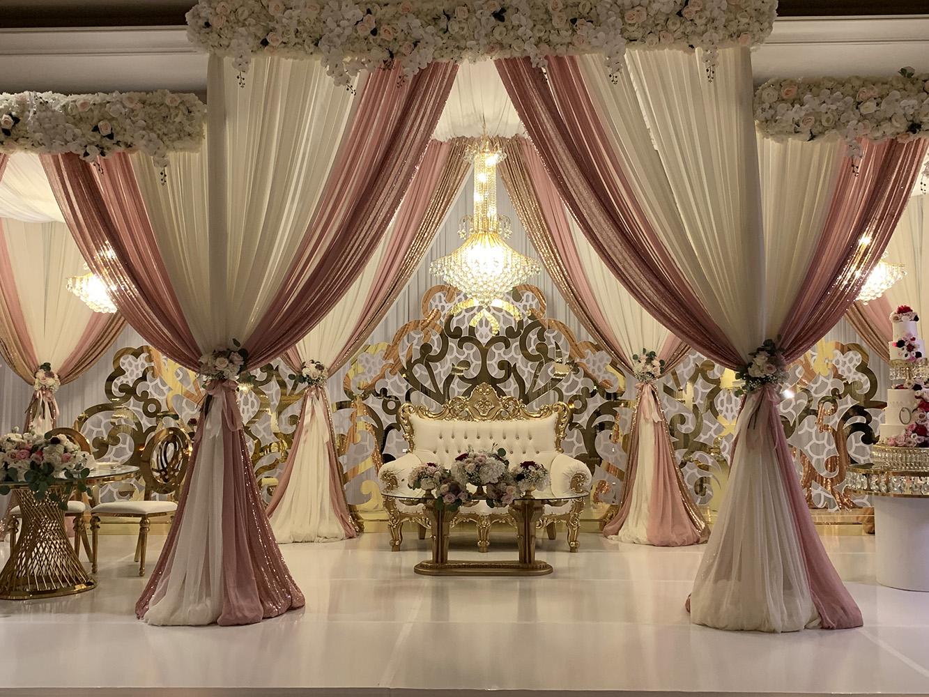 View Michelle and Anzon's luxury wedding at Houston Marriott Sugar Land, featuring pink white and red flowers with gold accented decor.