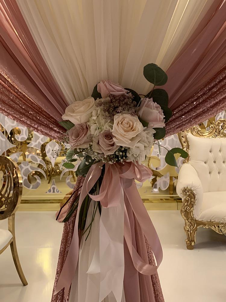 View Michelle and Anzon's luxury wedding at Houston Marriott Sugar Land, featuring pink white and red flowers with gold accented decor.