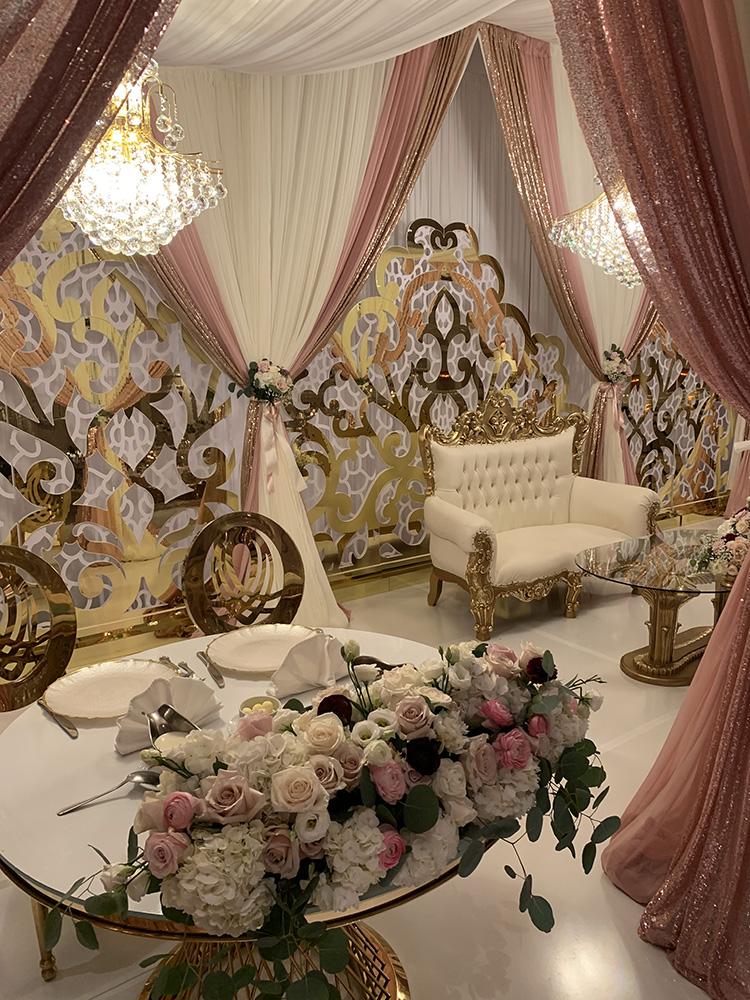 View Michelle and Anzon's luxury wedding at Houston Marriott Sugar Land, featuring pink white and red flowers with gold accented decor.
