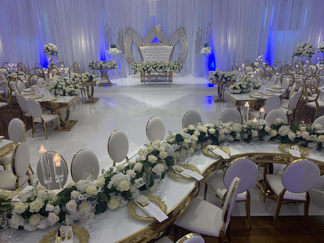 NOAH’s Event Venue. Featuring gold and white wedding decor, with blue uplighting.