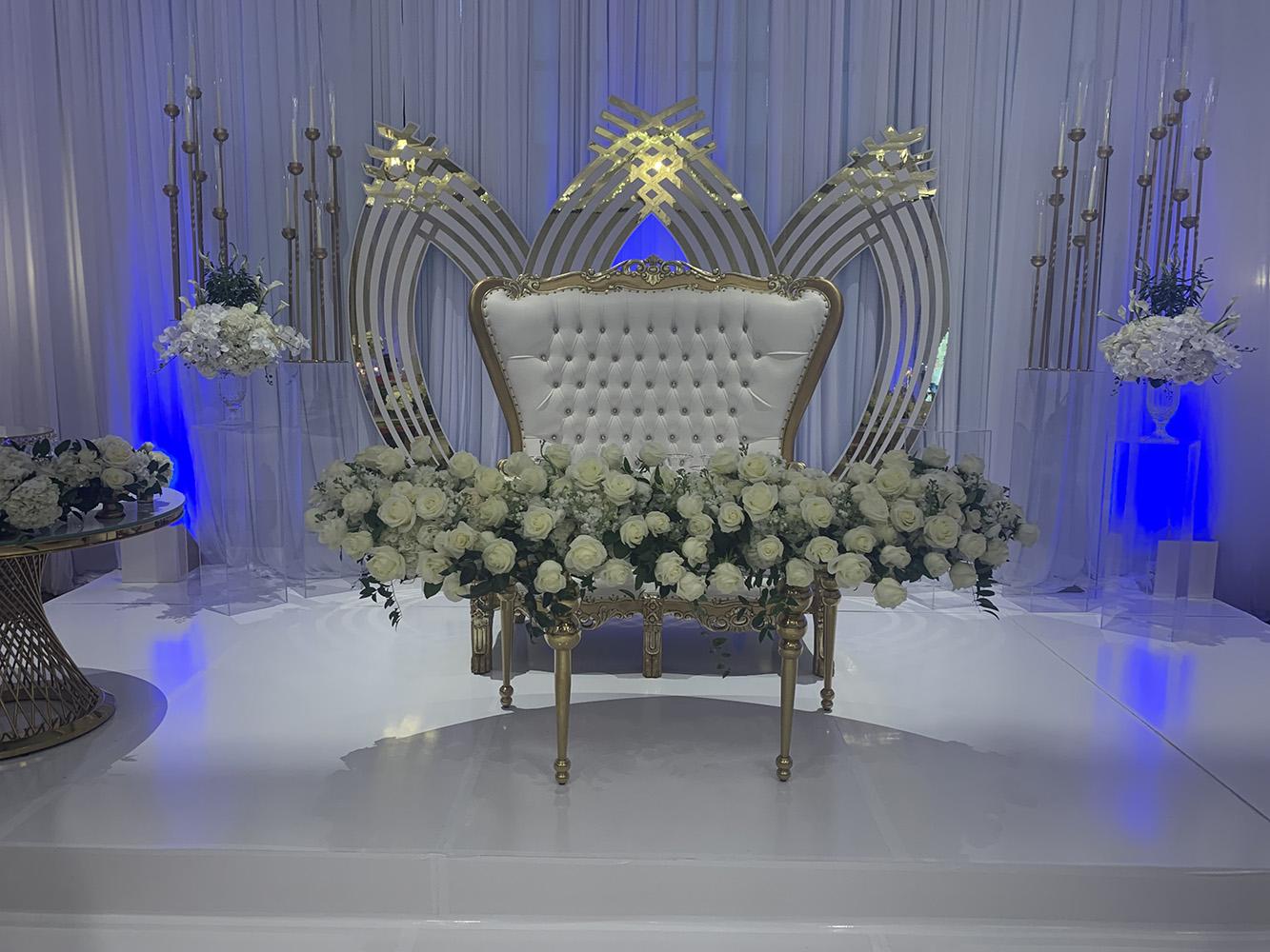 NOAH’s Event Venue. Featuring gold and white wedding decor, with blue uplighting.