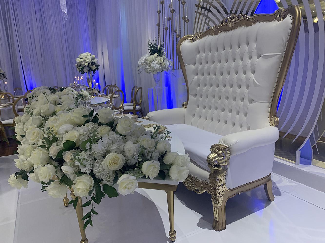 NOAH’s Event Venue. Featuring gold and white wedding decor, with blue uplighting.