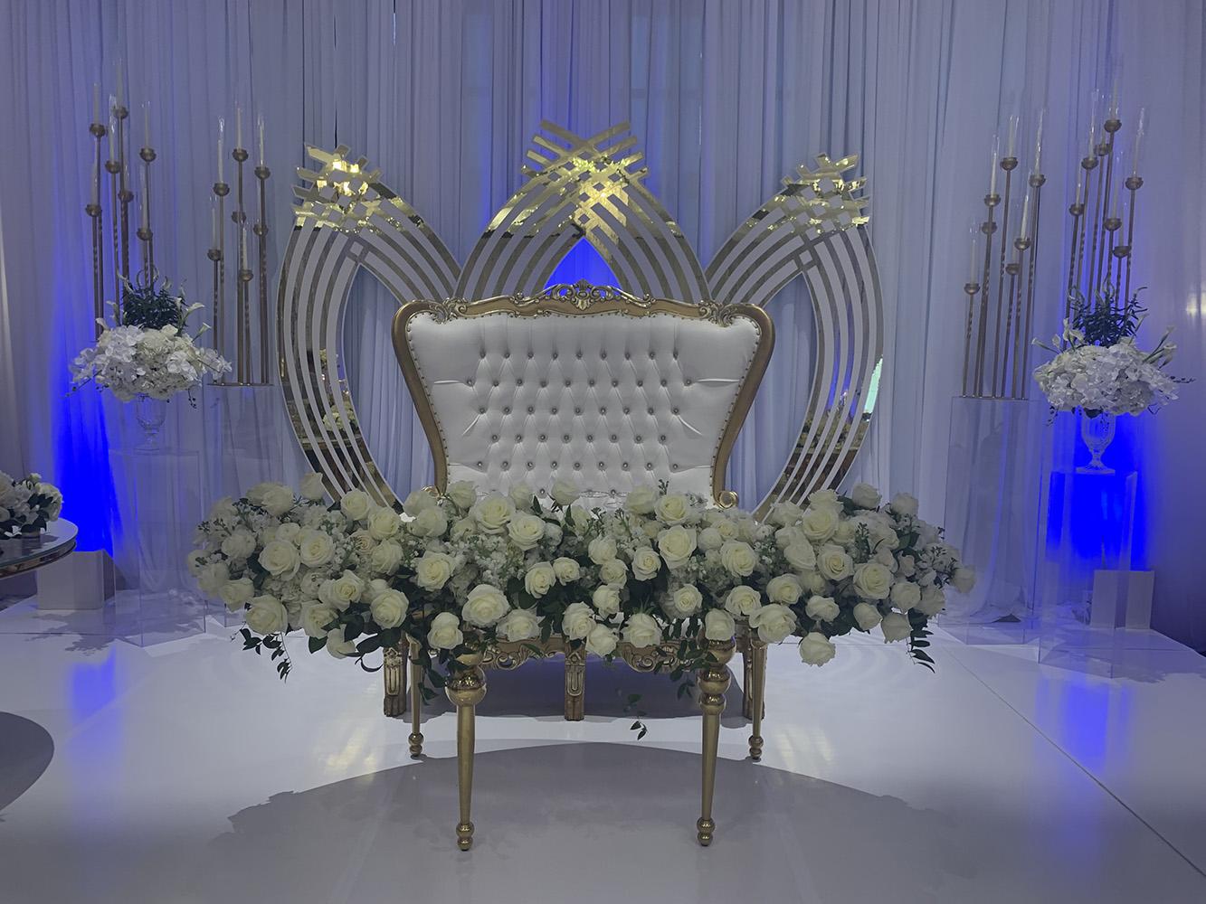 NOAH’s Event Venue. Featuring gold and white wedding decor, with blue uplighting.