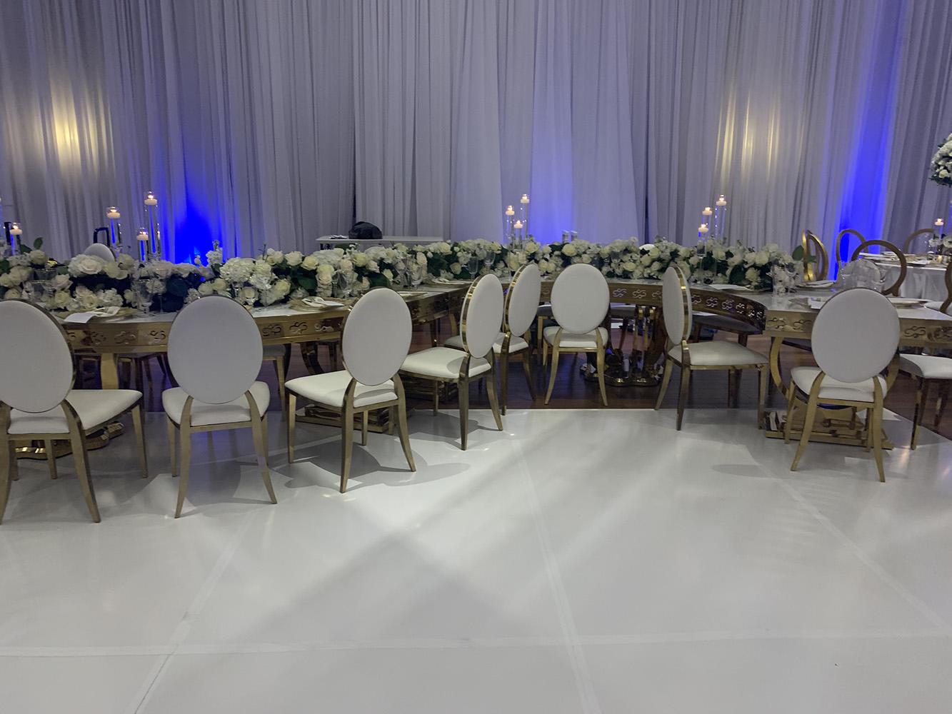 NOAH’s Event Venue. Featuring gold and white wedding decor, with blue uplighting.