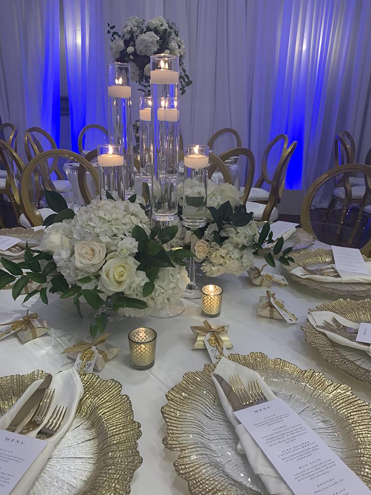 NOAH’s Event Venue. Featuring gold and white wedding decor, with blue uplighting.