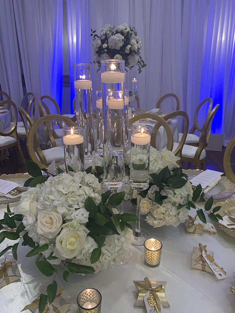 NOAH’s Event Venue. Featuring gold and white wedding decor, with blue uplighting.