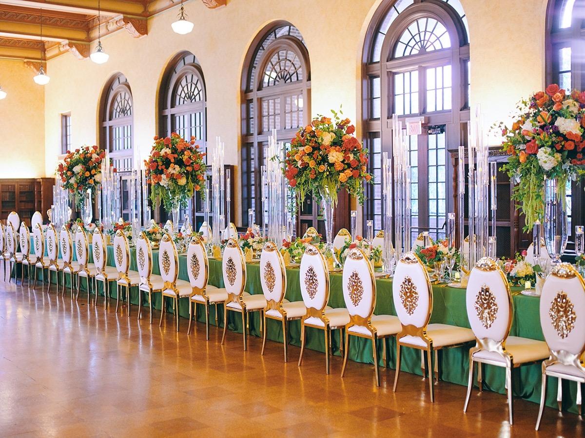 luxury wedding decor for weddings in houston at julia ideson library - gold chairs - long tables - clear vases