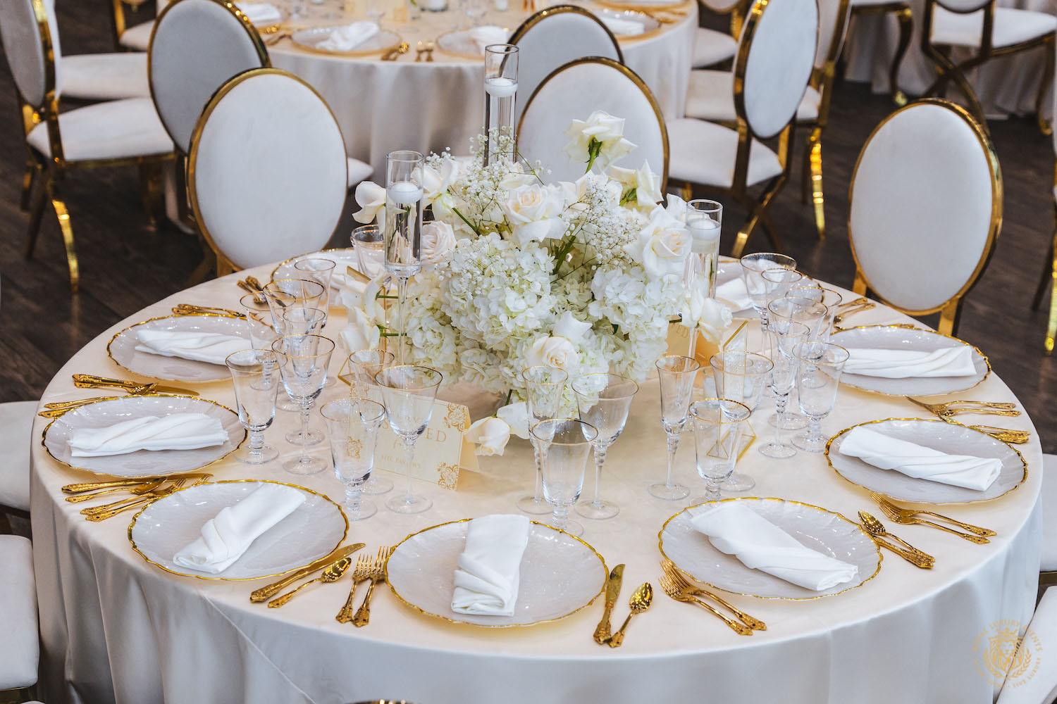 wedding reception table, white and gold chair rentals, low floral centerpieces