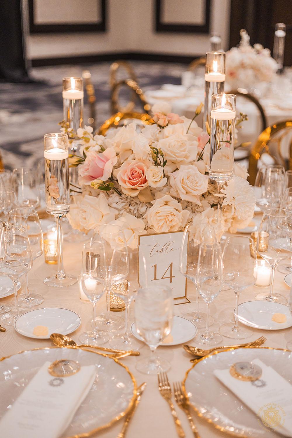 gold chargers, tablescape, wedding place setting, low floral centerpieces, gold flatware, floating candles, candle decor